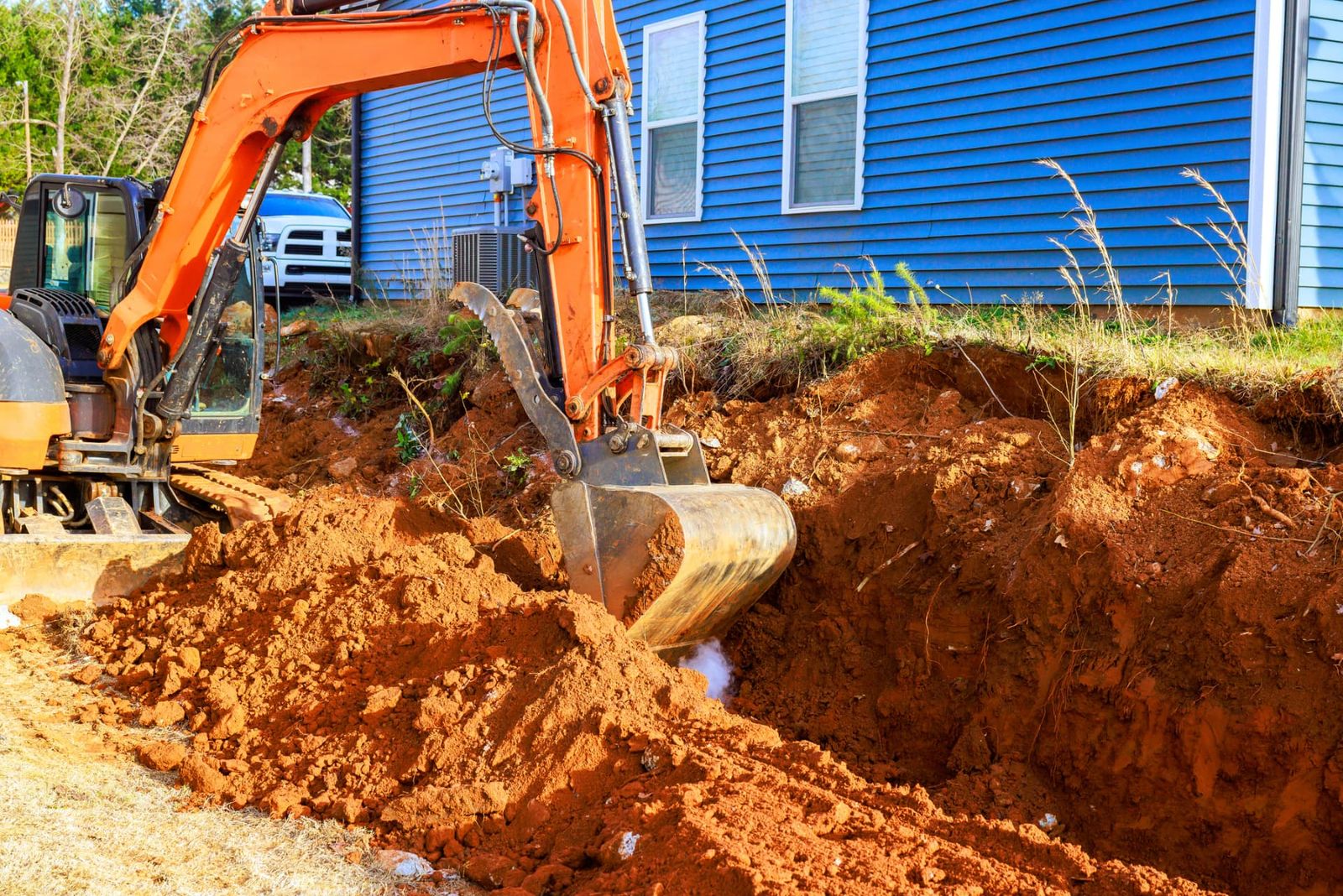 Excavator grading soil on a rural building site near Chipley, Florida