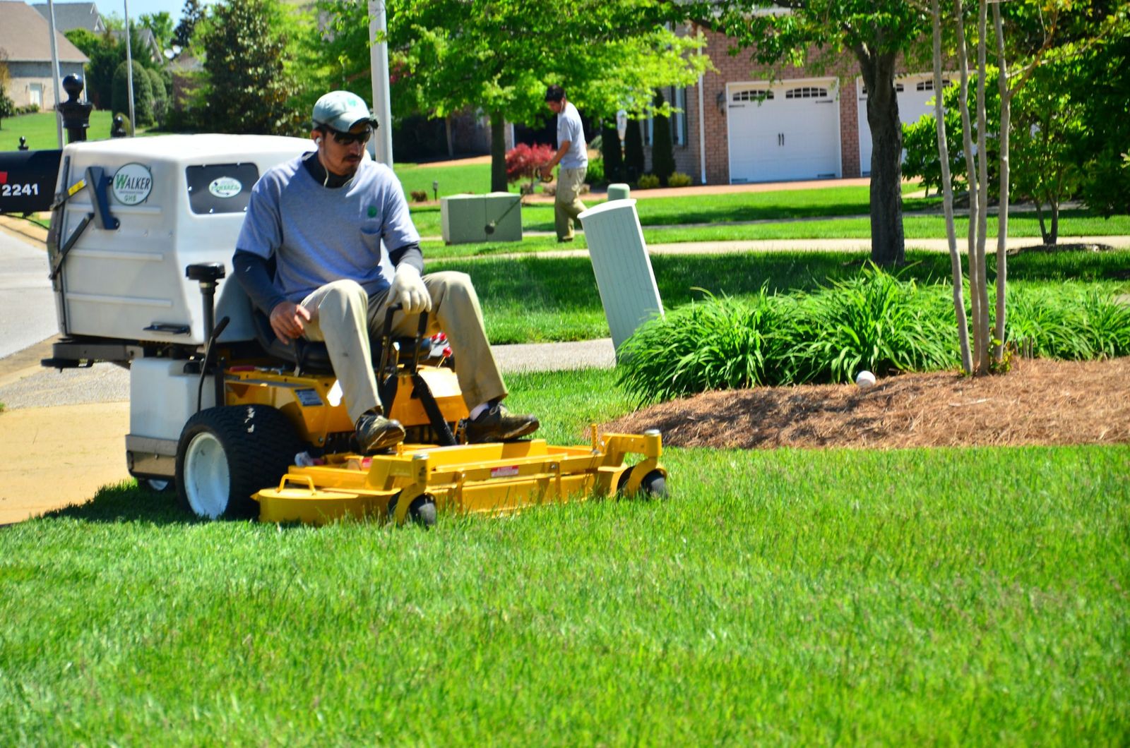 Lawn care professional mowing a striped green lawn at a Chipley, FL home